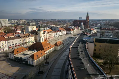 Rynek z ratuszem i katedralnymi wieżami w szerokim spojrzeniu z góry.