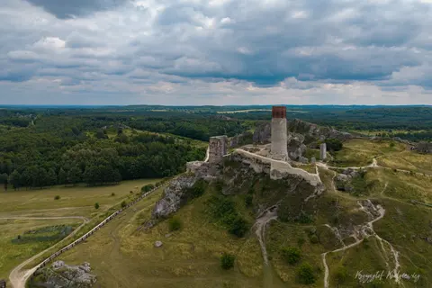 Ruiny zamku i wysoka wieża otwierają się na rozległą panoramę zielonych wzgórz.