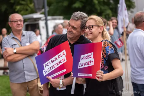 Uśmiechnięte osoby z tabliczkami „Polska dla wszystkich” i „Miłość zwycięży”.